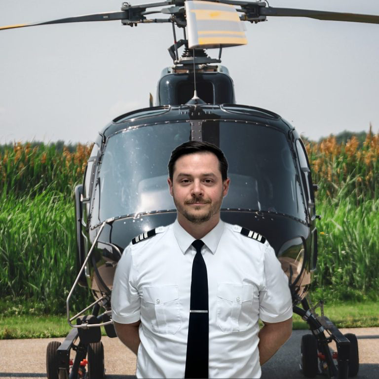 Thibault Oulès en uniforme de pilote devant un hélicoptère